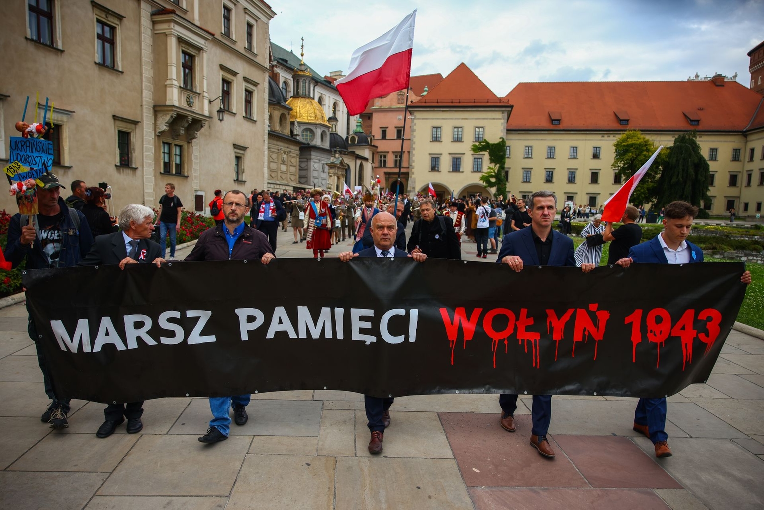 People hold banners and Polish flags during a march commemorating Polish victims of the Volyn massacres carried out during World War II in Krakow, Poland, on July 11, 2024.