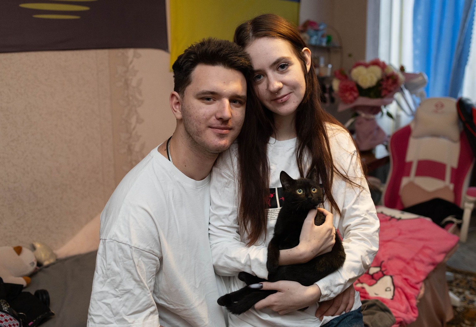 Viacheslav Pylypenko and Darusia Pylypenko with their rescued cat Misa from Novopavlivka, Donetsk Oblast, in Kyiv, Ukraine, on Sept. 28, 2025.