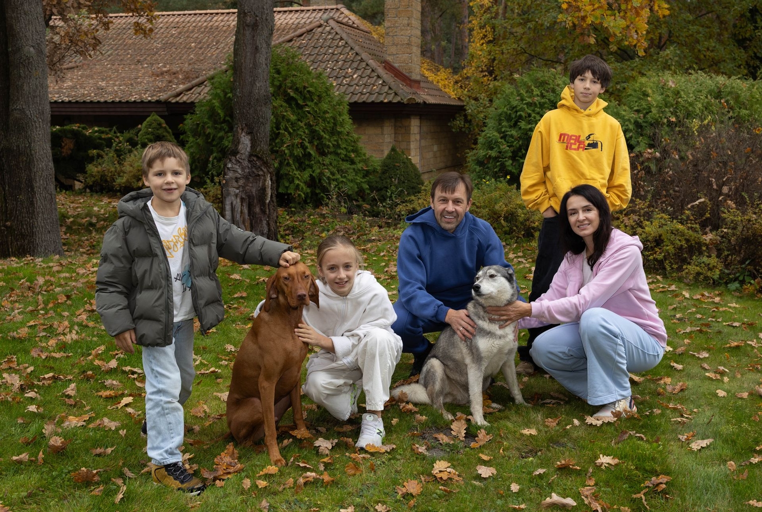 Onistrat family and their rescued dogs Divchulia and Hugo in Bobrytsia, Kyiv Oblast, Ukraine, on Oct. 22, 2025.
