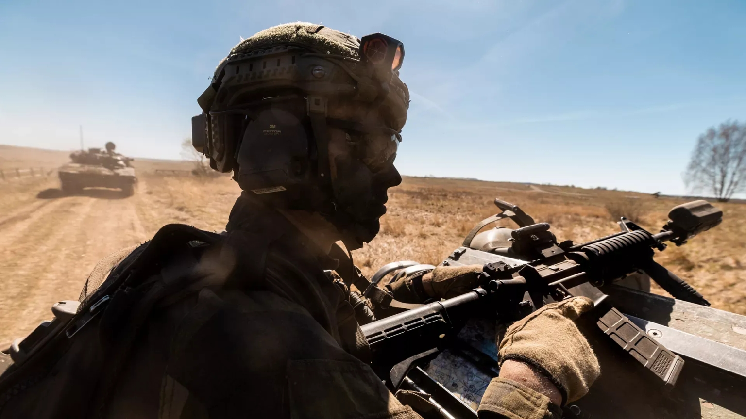 A soldier with the Swedish Army's South Skåne Regiment looks out of a CV90 Infantry Fighting Vehicle during Exercise Aurora 26 near Revingehed, Sweden, in May 2026.