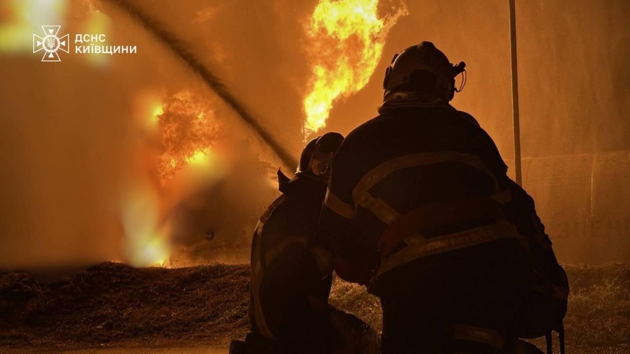 Two firefighters put out a fire