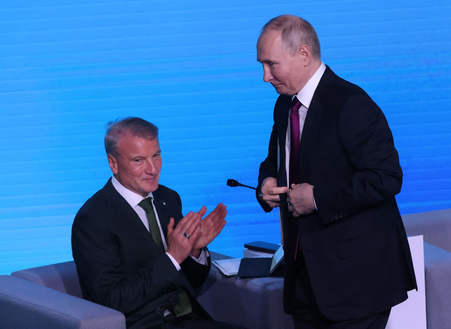 Putin (R) smiles as Sberbank CEO Herman Gref (L) applauds during an artificial intelligence forum in Moscow, Russia, on Nov. 19, 2025.