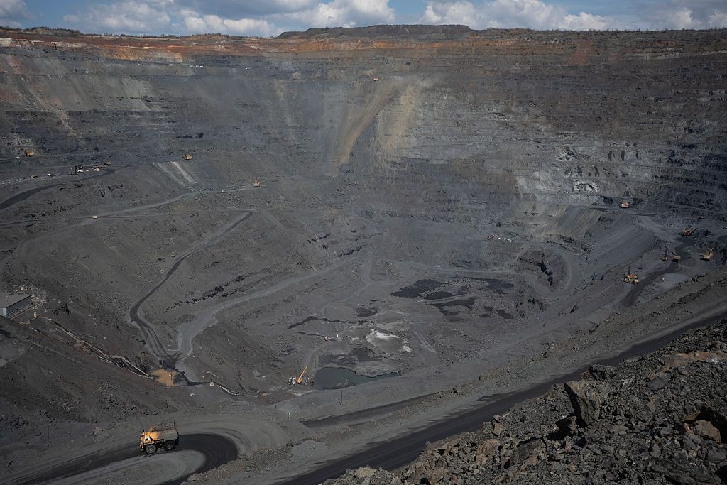 A large open-pit mine with steep, terraced walls and winding haul roads.