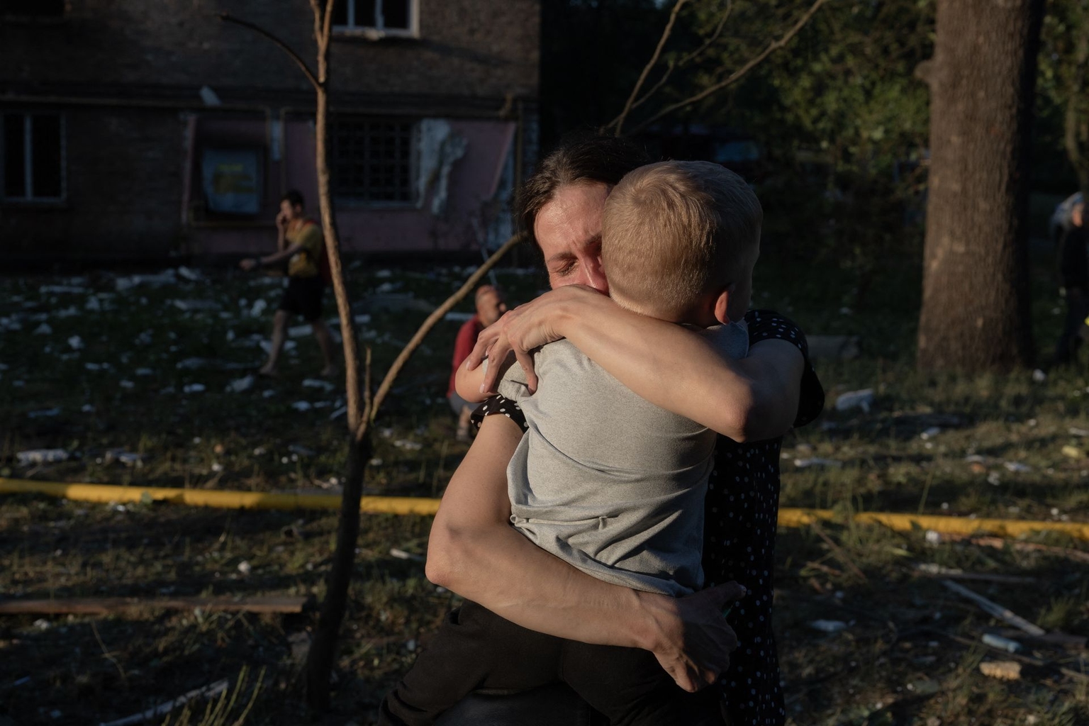 A woman holding a child cries next to a residential building damaged in a Russian air attack on Kyiv, Ukraine, on July 2, 2026.