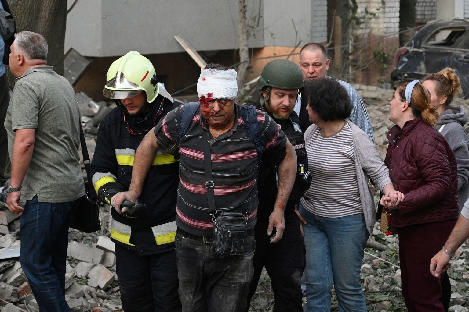 First responders escort a wounded resident outside a residential building partially destroyed by Russian missile strikes in Lviv, Ukraine, on July 30, 2026.