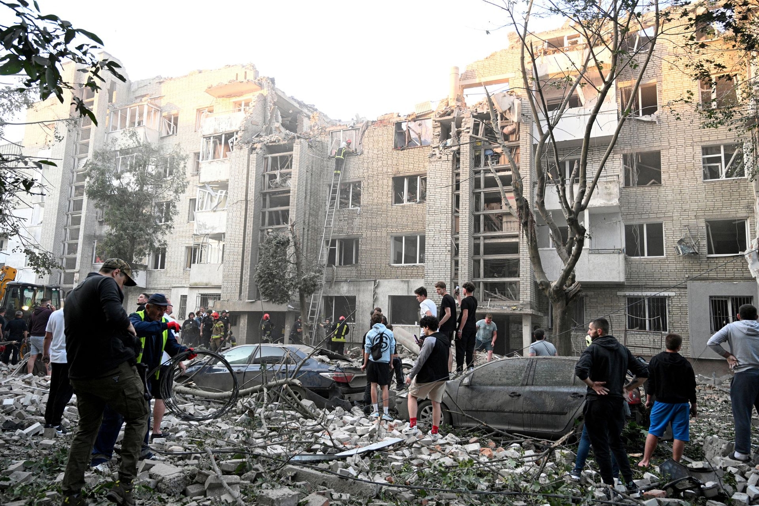 Local residents watch as first responders operate at a residential building partially destroyed by Russian missile strikes in Lviv, Ukraine, on July 30, 2026.