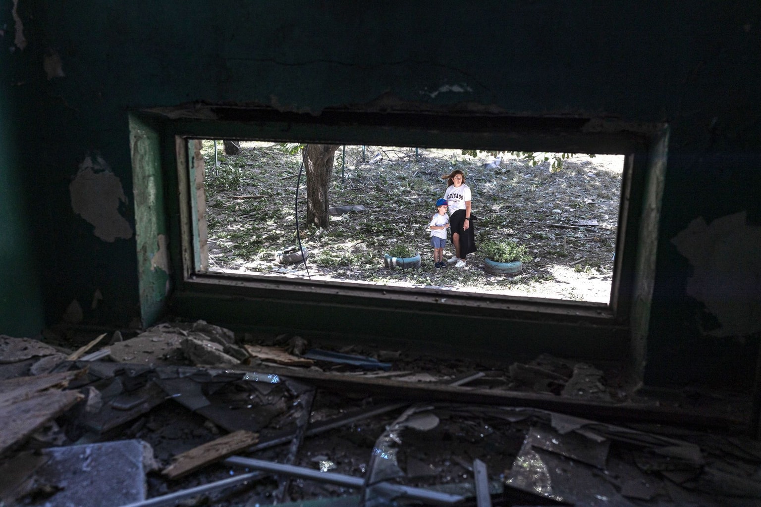 A mother and her son stand at the scene of a Russian attack in Sloviansk, Ukraine, on June 21, 2026.