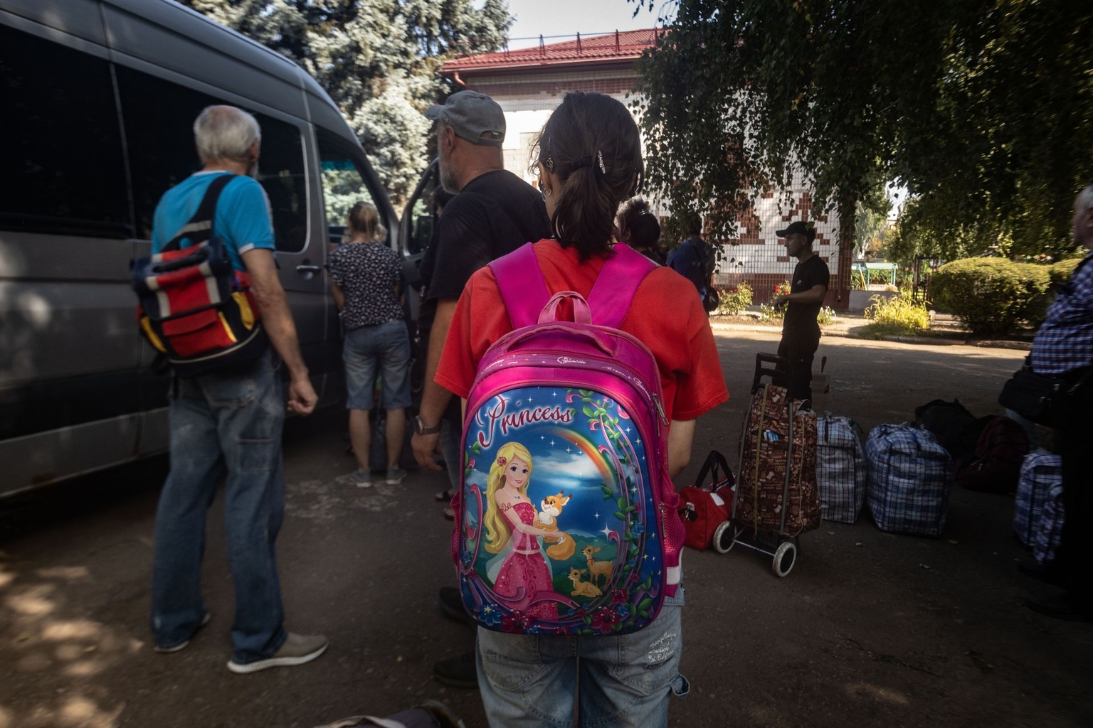 A young girl stands with her belongings during an evacuation in Kramatorsk, Ukraine, on August 8, 2026.