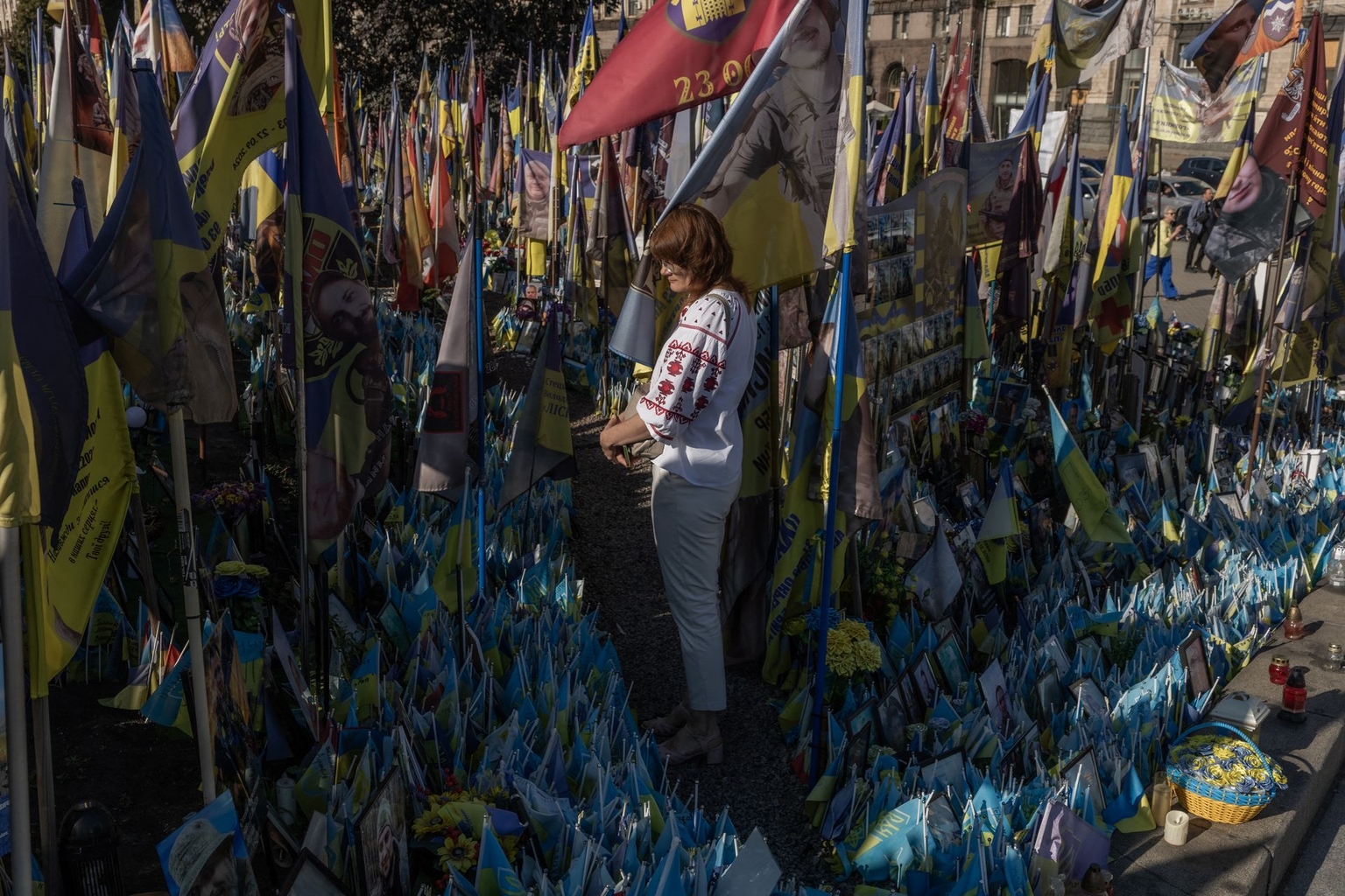 A woman visits a makeshift memorial for fallen Ukrainian and foreign soldiers on Independence Square in Kyiv, Ukraine, on Aug. 24, 2026.