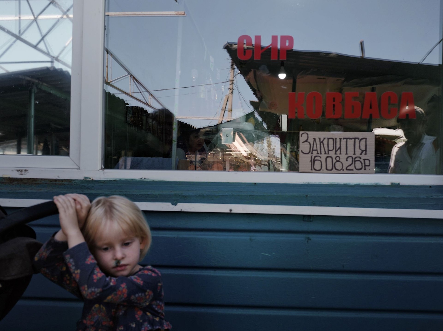 A girl stands by a shop closing before its owners evacuate in Kramatorsk, Ukraine, on August 16, 2026.