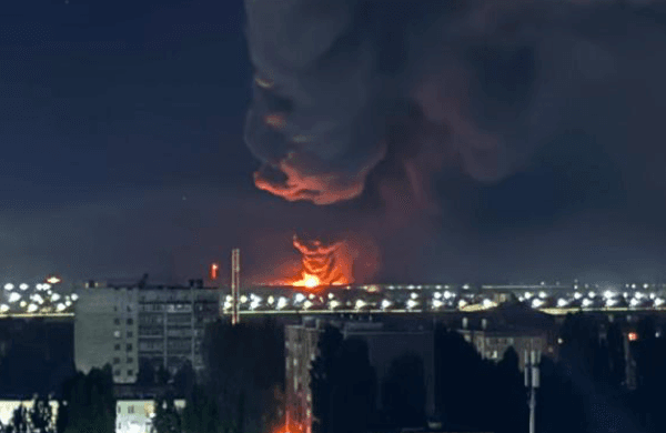 Smoke rises over a fire in the distance