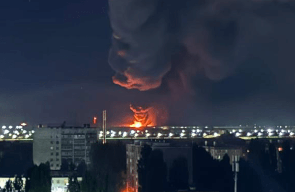 Smoke rises over a fire in the distance