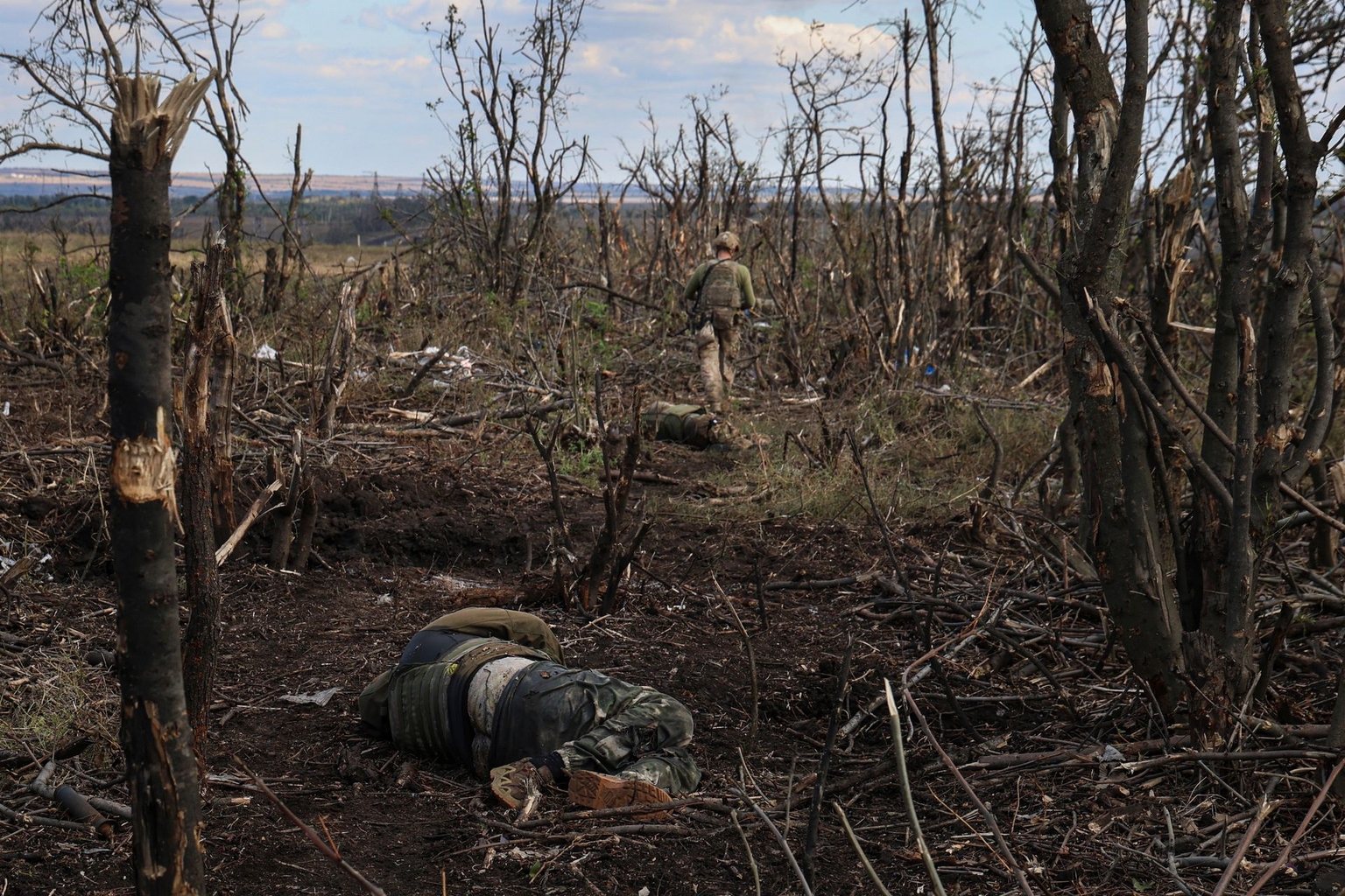 Assault unit commander from the 3rd Assault Brigade, who goes by the call sign "Fedia," passes by the bodies of dead Russian soldiers at the front line on the way to Andriivka, Donetsk Oblast, Ukraine, on Sept. 16, 2023.