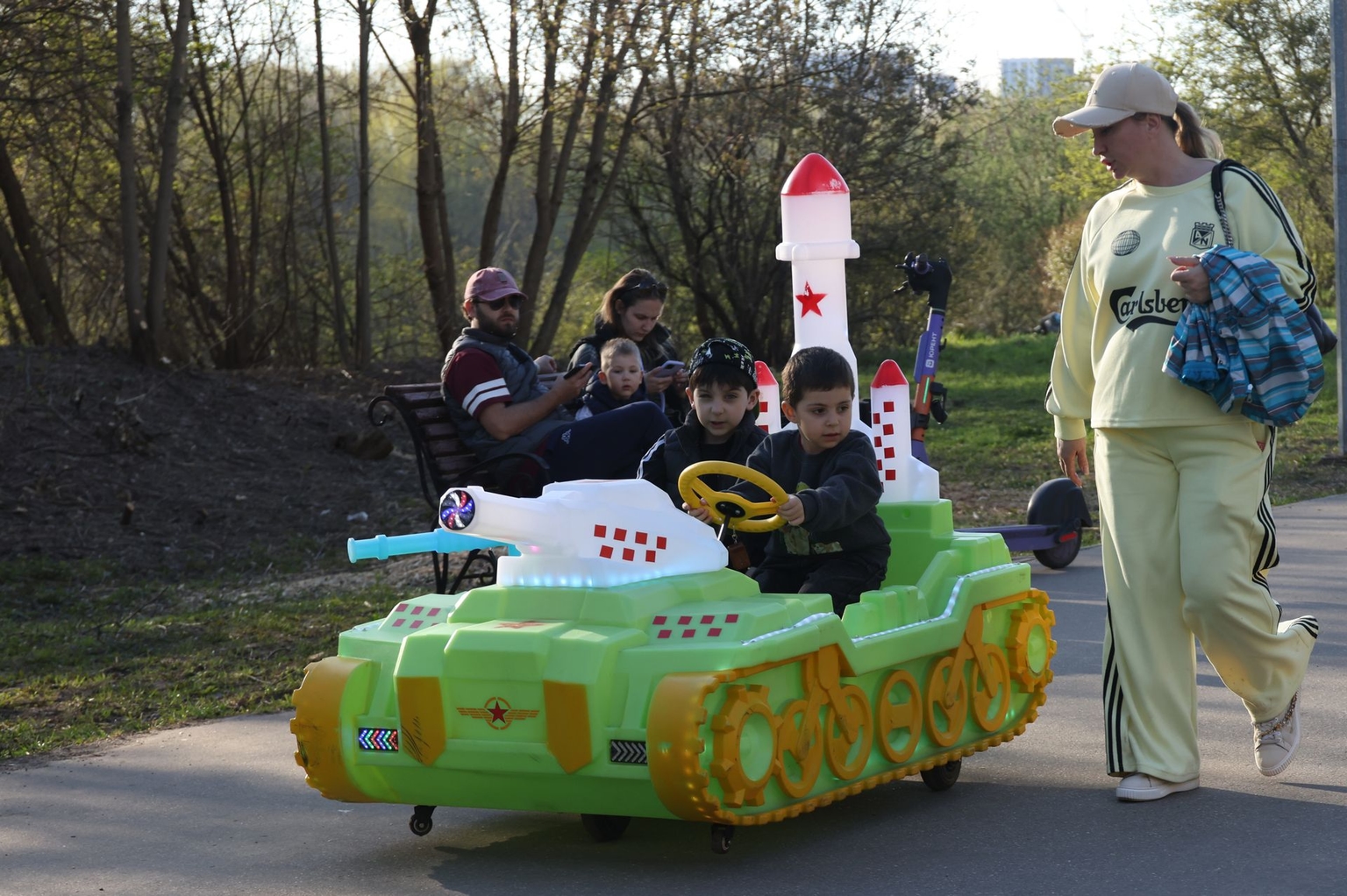 Children ride an electric car shaped like a military tank with a missile array in a city park outside Moscow, Russia, on May 3, 2026.