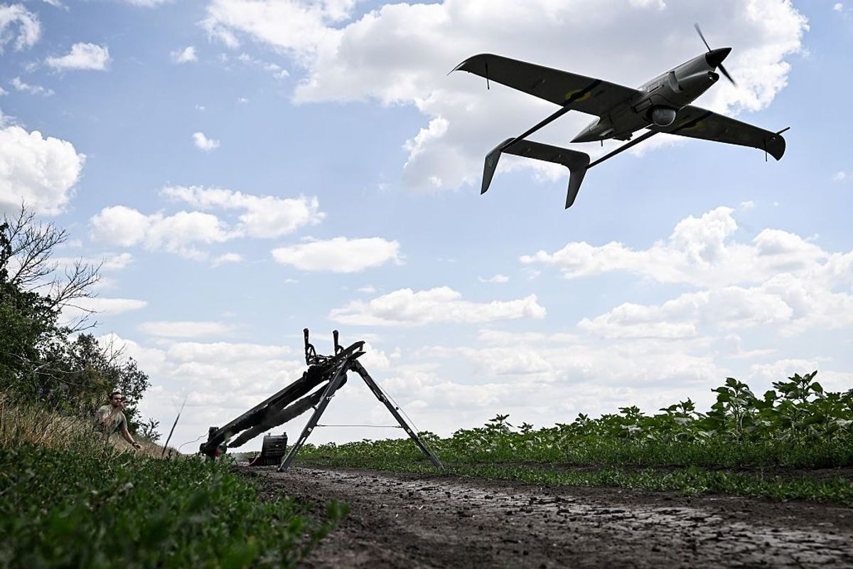 A technician launches a Ukrainian Raybird (ACS-3) UAV from a catapult.