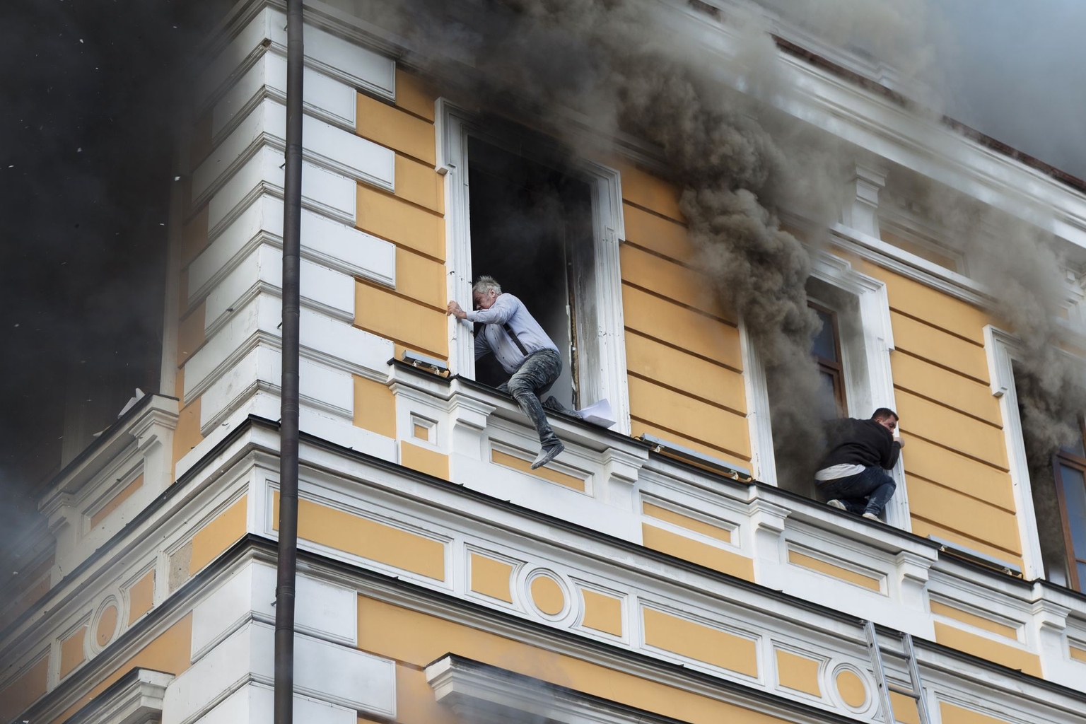 Two men flee a burning building after a drone strike in Kyiv, Ukraine, on Sept. 28, 2026.