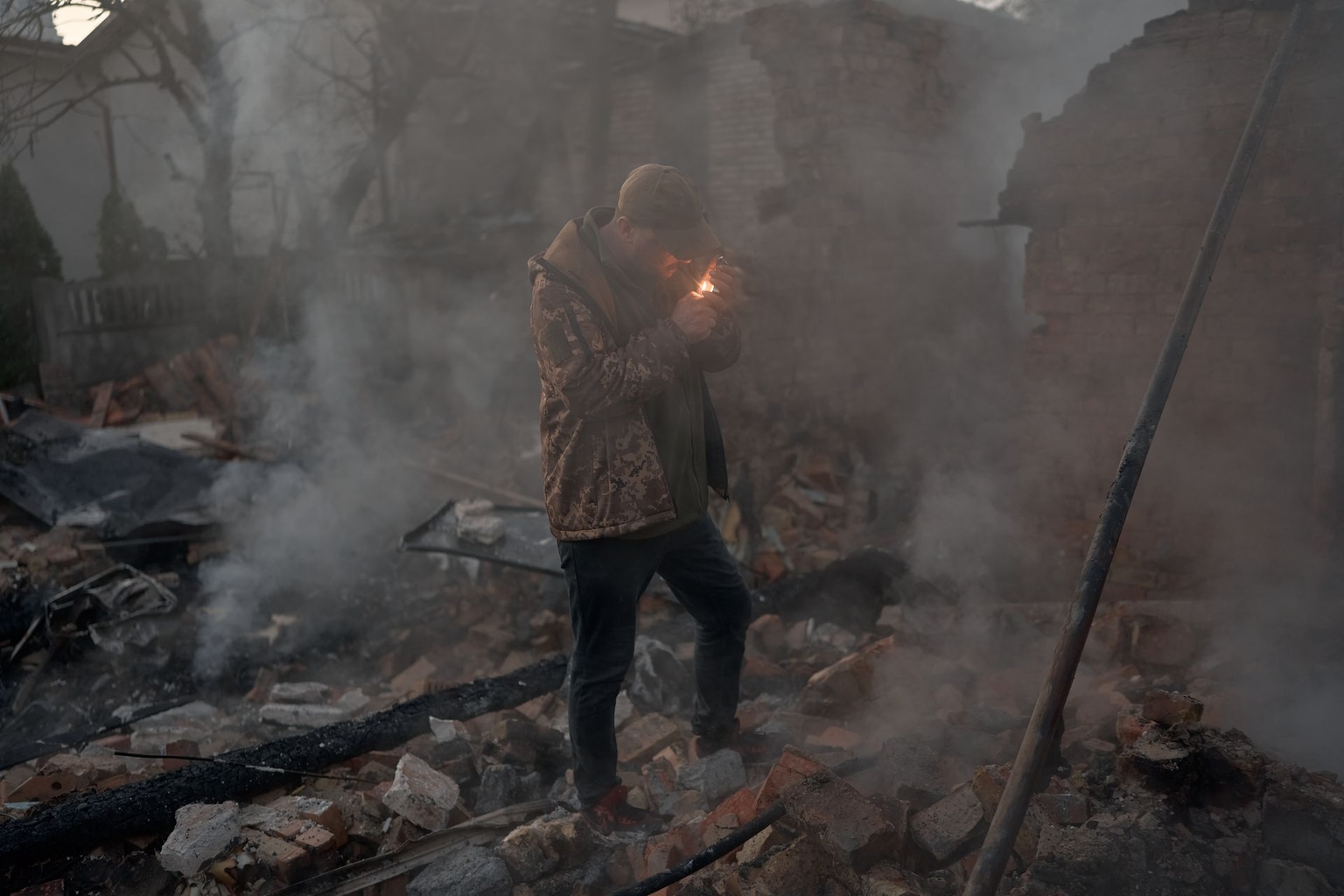 A man lights a cigarette as emergency workers clear rubble in Kyiv, Ukraine, on Sept. 30, 2026.