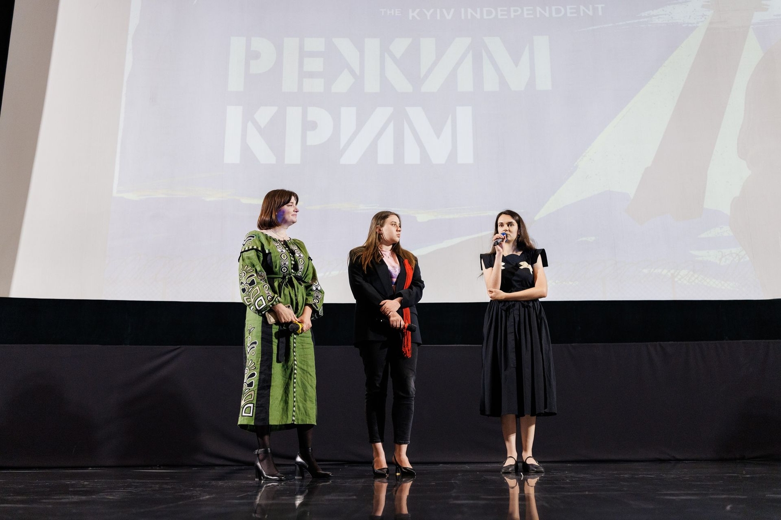 The Kyiv Independent's War Crimes Investigation Unit team Yevheniia Motorevska, Myroslava Chaiun, and Olesia Bida (from left to right) taking audience questions on stage at a premiere of Last Seen in Crimea in Kyiv, Sep. 11, 2026 (Yevhen Poltavets/The Kyiv Independent)
