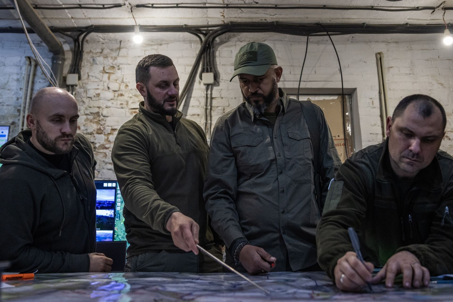 Khartia Brigade personnel review maps and drone feeds at a command center in Kharkiv on May 15, 2024.