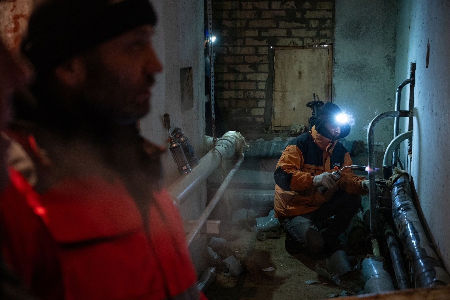 Repair workers thaw frozen pipes in a residential building in Kyiv, Ukraine, on Jan. 21, 2026.