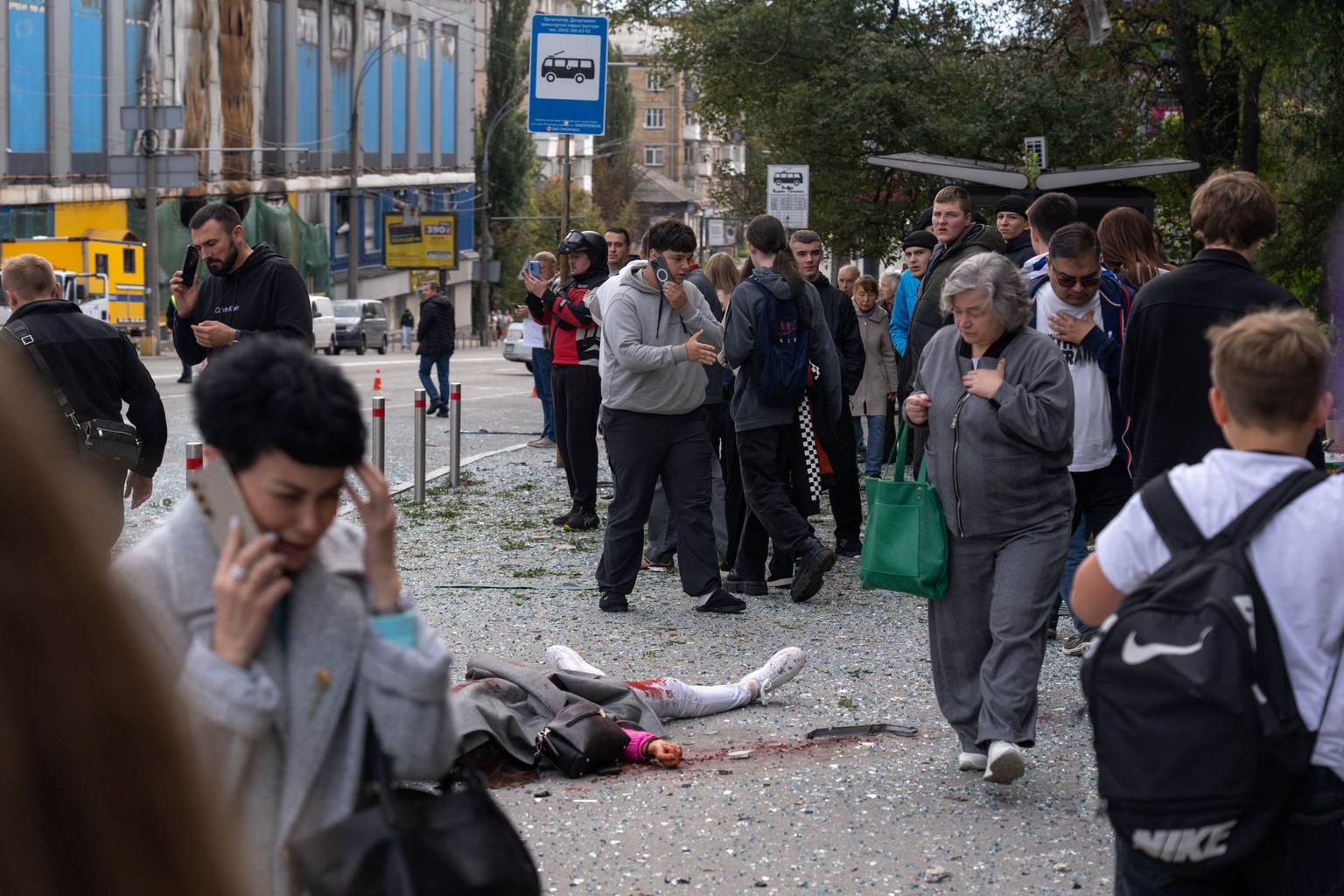 Pedestrians walk past the body of a victim after an air attack in Kyiv, Ukraine, on Sept. 25, 2026.