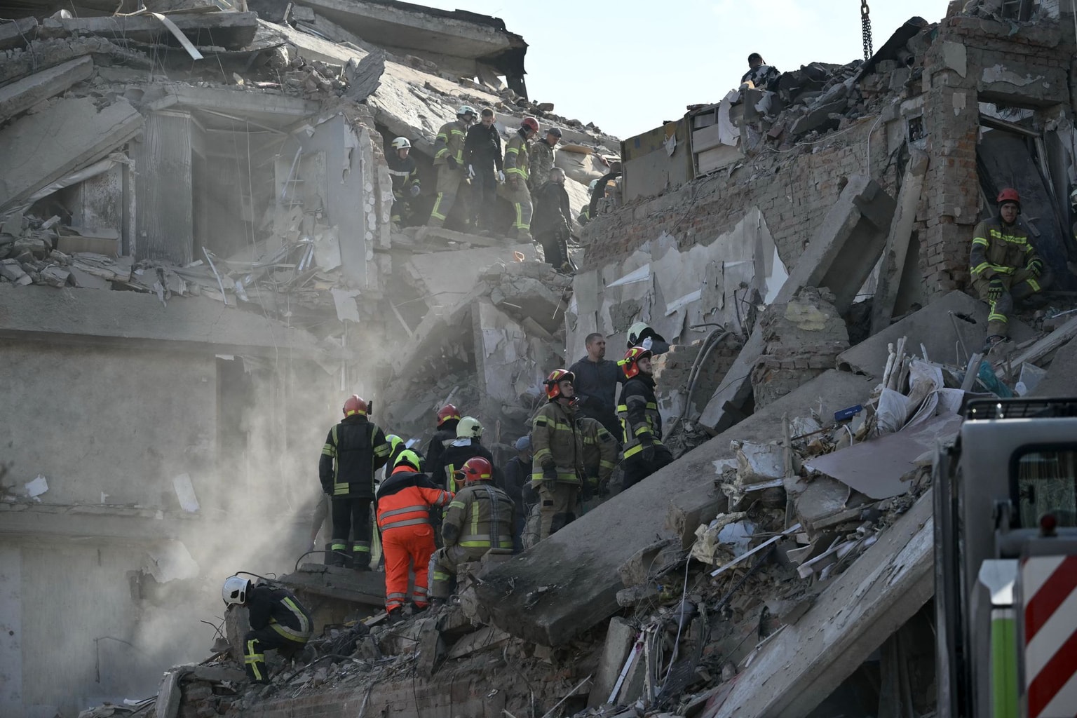 Rescuers conduct search and rescue operations at the site of a Russian aerial strike at a multi-floor residential building