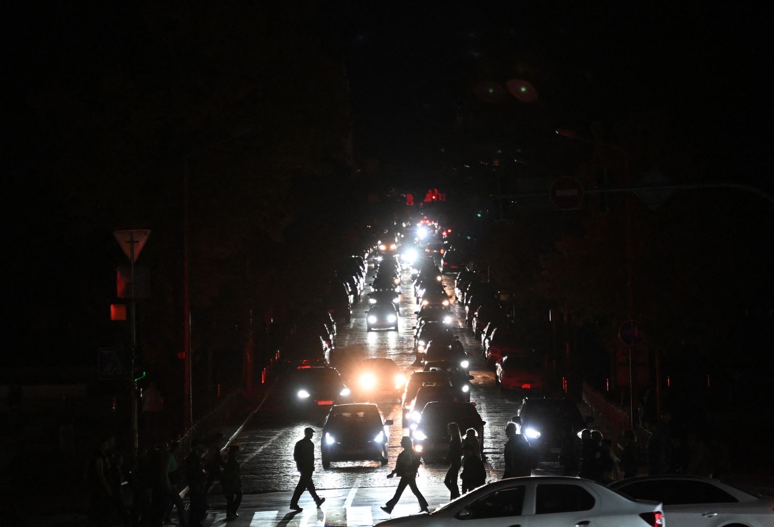 Pedestrians walk down a dark street during a blackout in Kyiv, Ukraine, on Oct. 8, 2026, amid the Russian invasion of Ukraine.