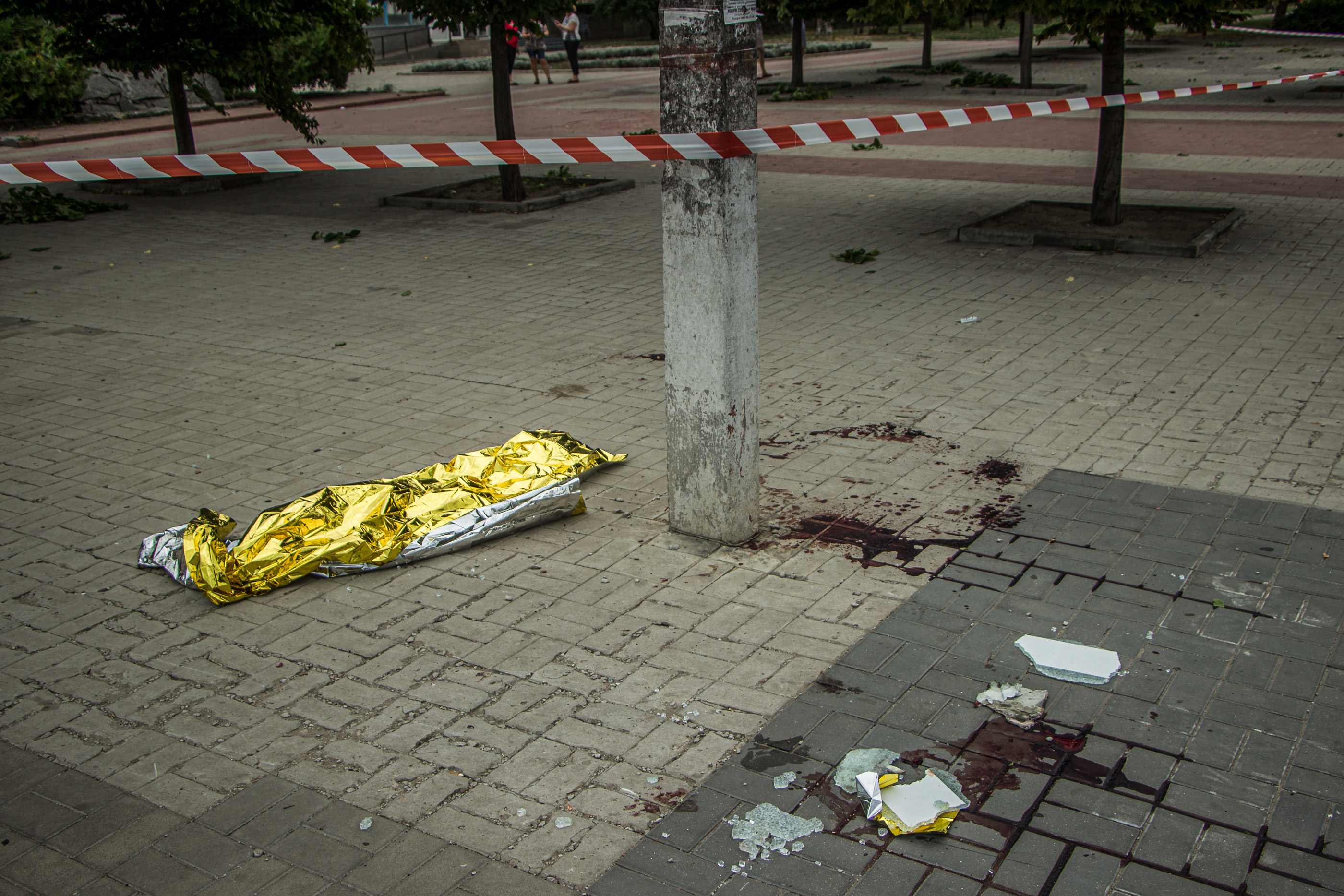 A white and red ribbon delimitates the square where a Russian cluster bomb﻿﻿ killed five in Mykolaiv on July 29, 2022. (Mariia Horshkova/The Kyiv Independent)
