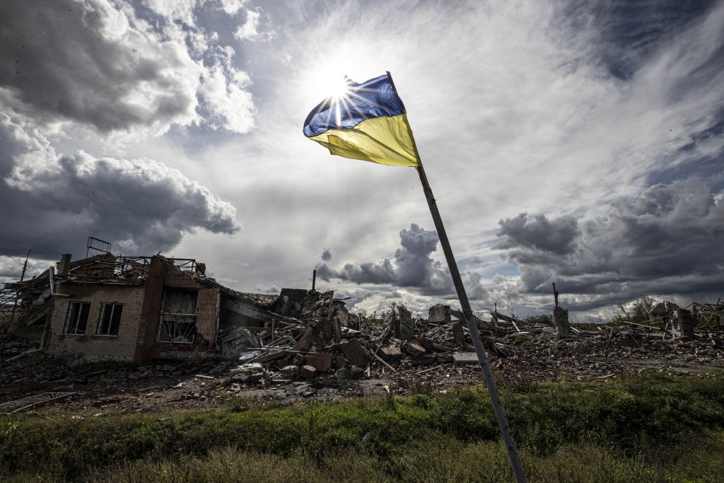 Ukrainian flags wave in a residential area heavily damaged in the village of Dolyna in Donetsk Oblast after Russian troops withdrew from the village on Sept. 24, 2022. (Metin Aktas / Getty Images)