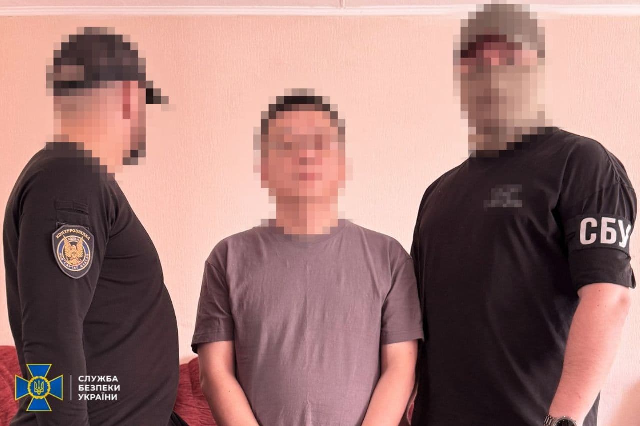 Two Ukrainian officers detain one of the Chinese nationals in Kyiv.